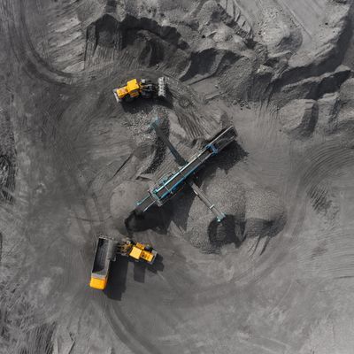 Aerial view of two yellow loaders and a conveyor system at a mining site.