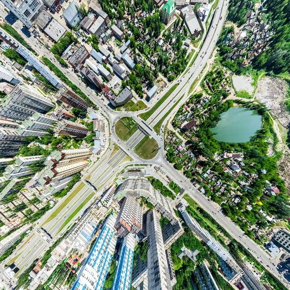 Aerial city view with crossroads and roads, houses, buildings, parks and parking lots, bridges. Helicopter drone shot. Wide Panoramic image.