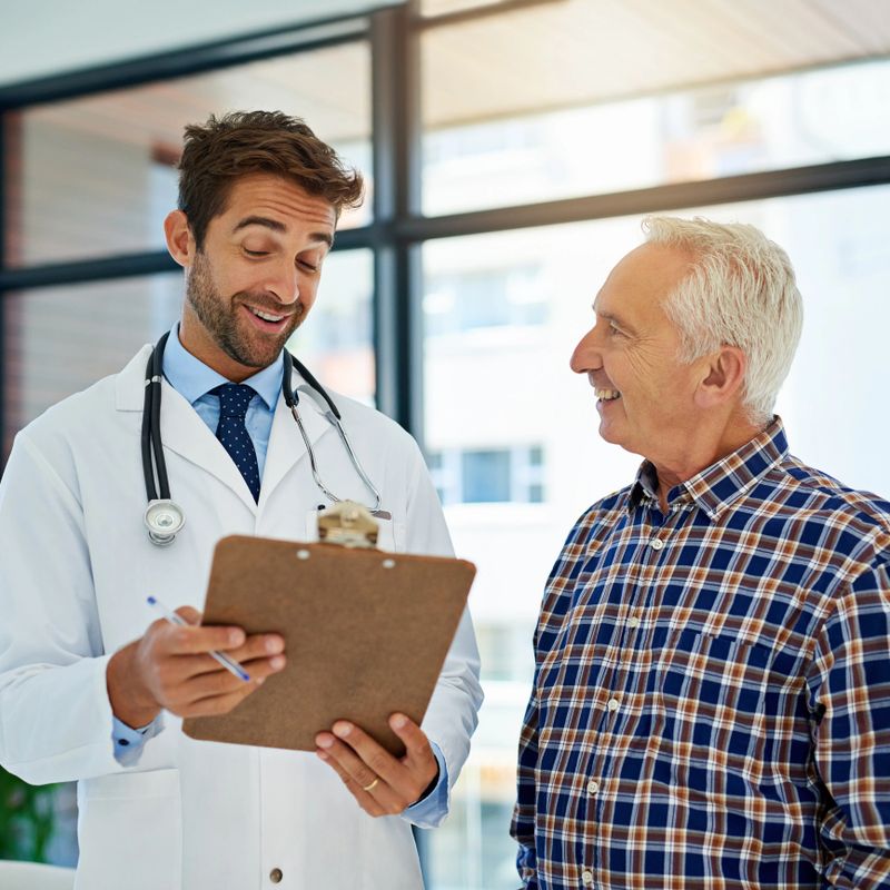 Shot of a cheerful doctor sharing good test results with his mature patient in the hospital