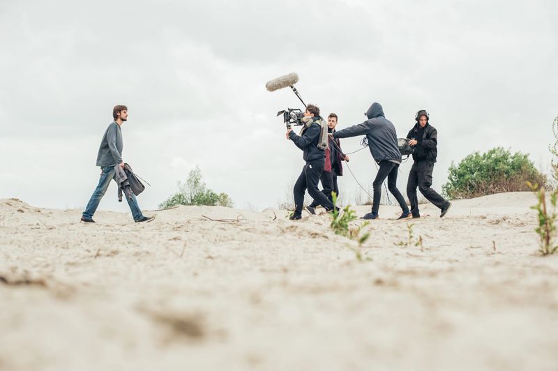 Behind the scene. Film crew team filming movie scene on outdoor location. Group cinema set