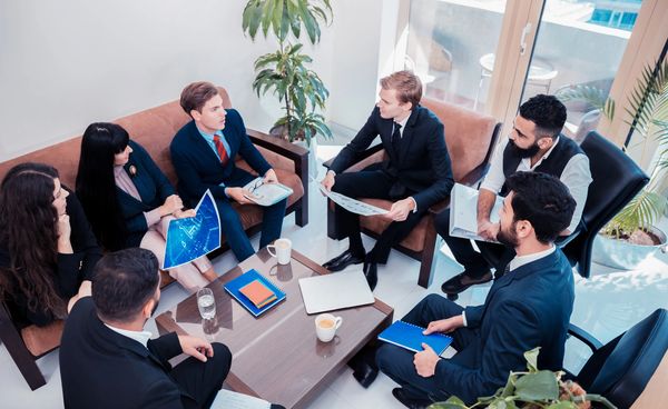 A group of professionals discussing charts and documents in a modern office.