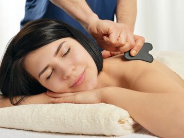 Gua sha therapy being carried out on the upper shoulders of a woman.
Gua sha in Leamington Spa.