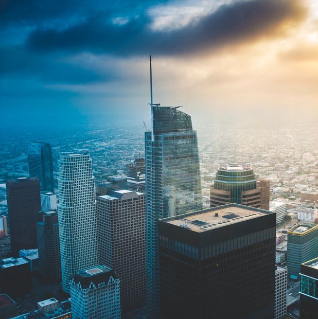 Skyscrapers and vibrant billboards fill the cloudy sky in a busy cityscape.