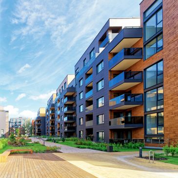 Modern apartment buildings with balconies under a bright blue sky.