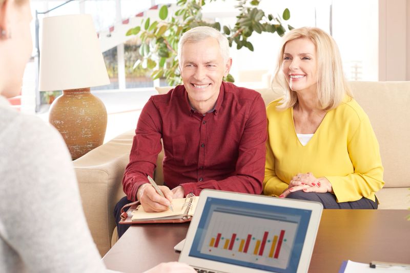 Shot of a happy elderly couple sitting at home and consulting with their financial advisor about savings.