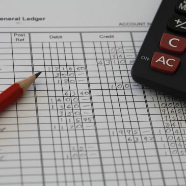 Pencil and calculator on a ledger sheet.
