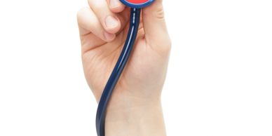 Hand holding a blue stethoscope with a red diaphragm.