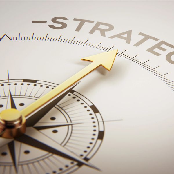 Golden compass needle pointing towards the word 'Strategy'.