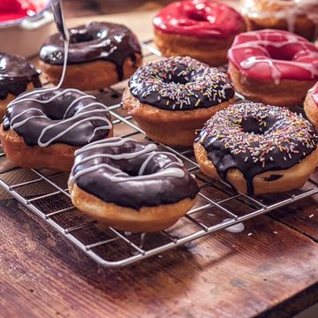 Assorted glazed and decorated donuts on a wire rack.