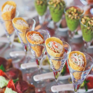 Elegant seafood cones served in cocktail glasses.
