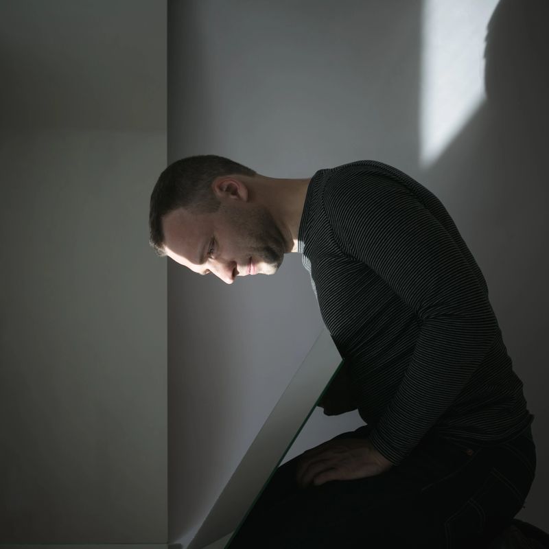 Artistic profile portrait of young European man looking in the mirror