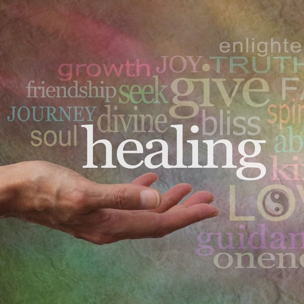 A hand reaching out with words of healing and positivity surrounding it.