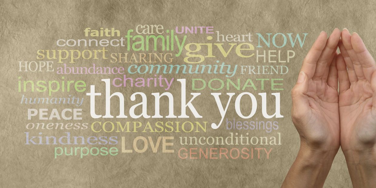 A word cloud of gratitude and kindness with hands cupped together on the right.