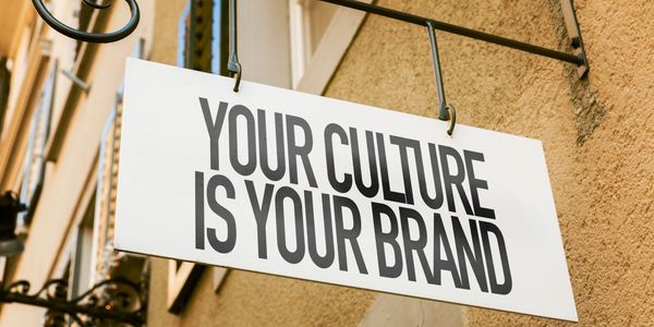 Signboard saying 'Your culture is your brand' hanging on a building.