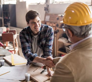 Calculator, ruler, pencil, and blueprints on a table.