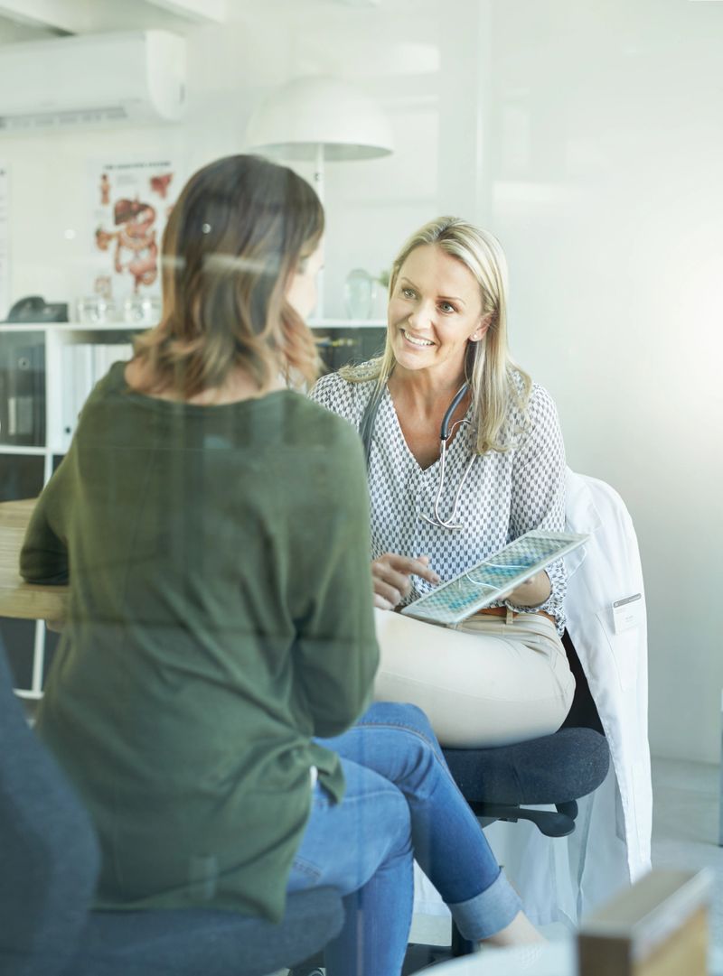 Cropped shot of a female doctor showing her patient something on her digital tablet