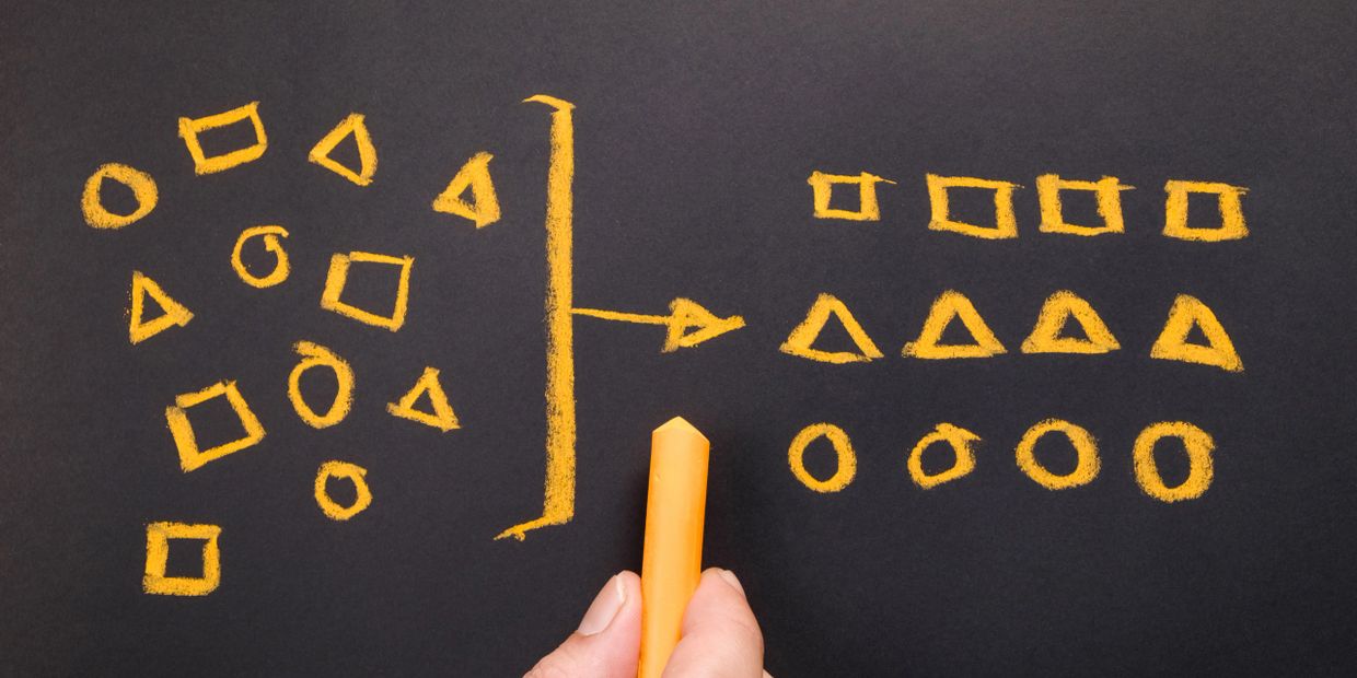 Grouping different shapes into organized categories on a blackboard.