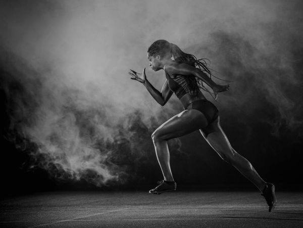 Femme athlète en course, photo en noir et blanc.