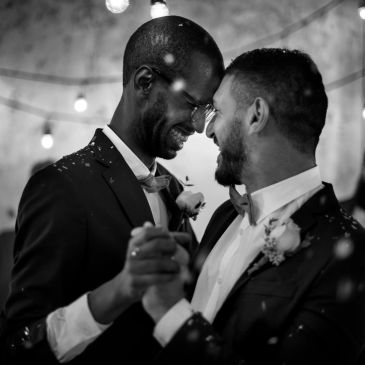 Two grooms newly wedded embrace during the first dance at their  wedding.