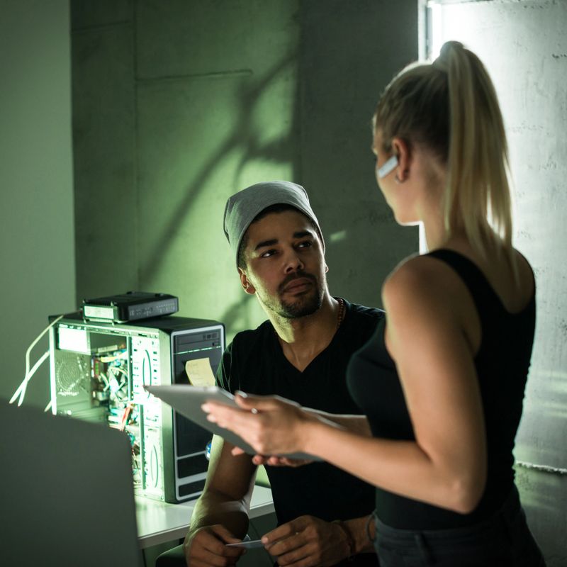 Cropped shot of two young computer programmers working on coding late at night.