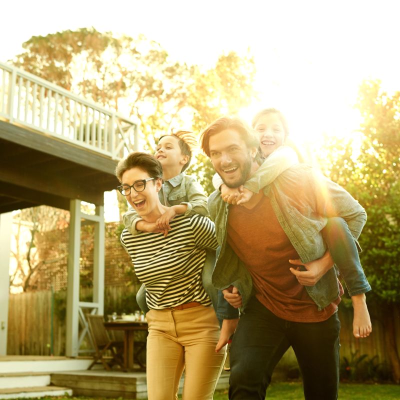 Shot of a happy couple playing with their young children in their backyard