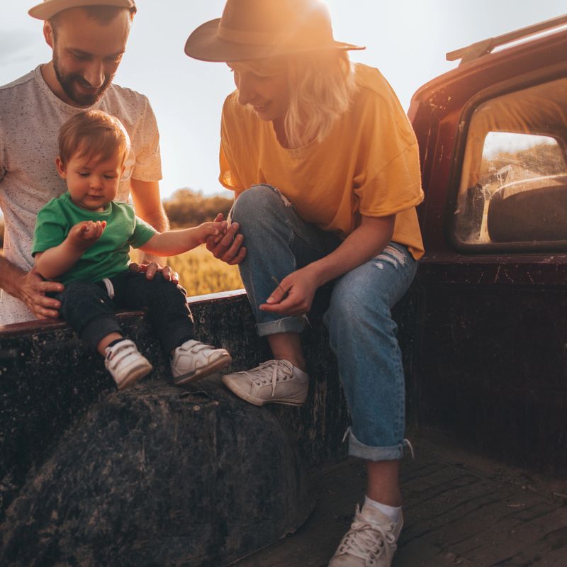 Photo of young family in their pick-up truck getting ready for new adventures with their baby