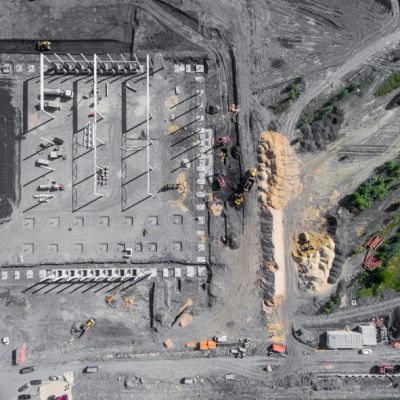 Aerial view of an industrial construction site with machinery and concrete structures.
