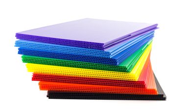 Stack of colorful corrugated plastic sheets.