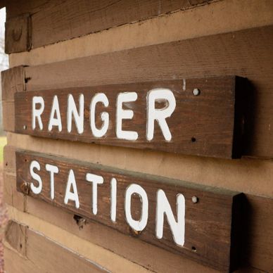 Wooden sign reading 'RANGER STATION' mounted on a cabin wall.