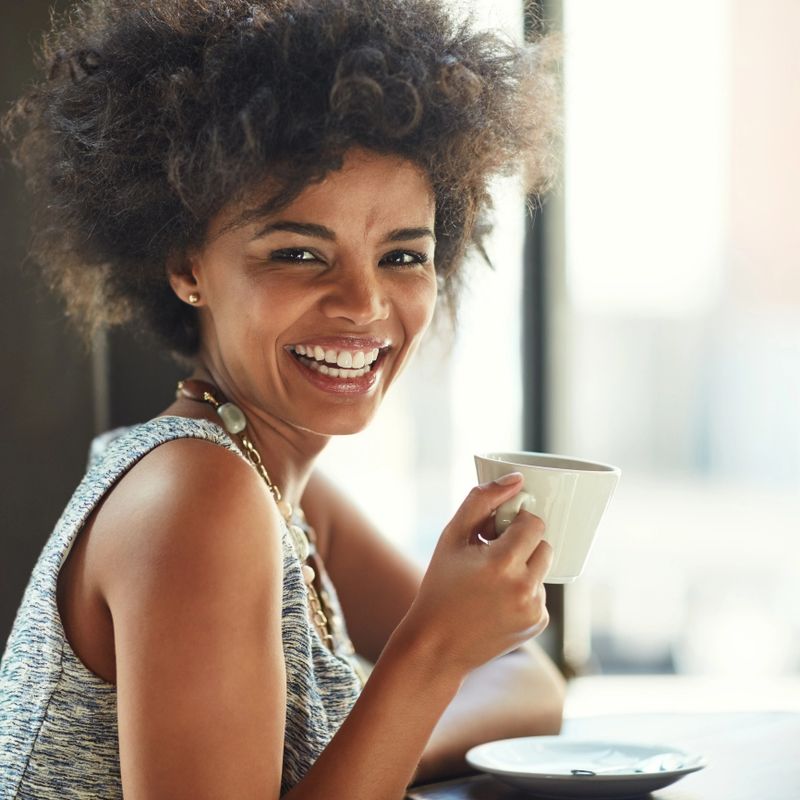 Portrait of a young woman enjoying a cup of coffee in a cafe