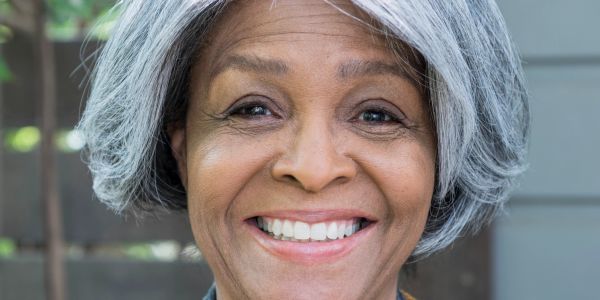 Mujer mayor sonriente con cabello canoso.