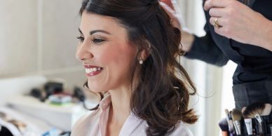 Woman getting her hair styled and smiling.