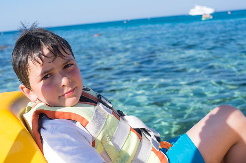 Young boy wearing life vest on boat