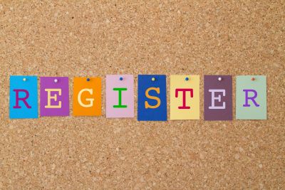 Colorful cards spelling REGISTER on corkboard.