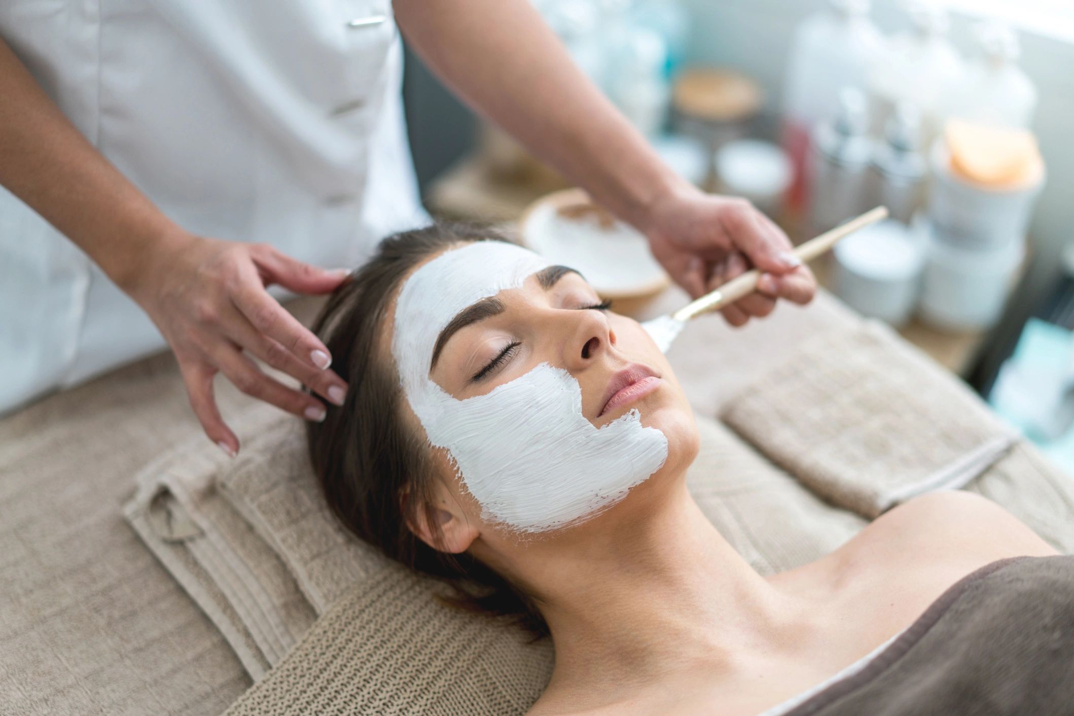 Woman receiving a facial mask treatment.