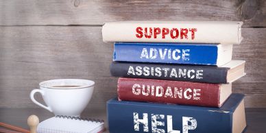 Stack of books with support-themed titles and a coffee cup.