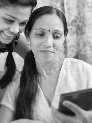 A mother and daughter sharing a moment looking at a smartphone together.