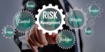 Gears representing risk management concepts with a hand pointing.
