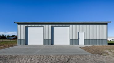 A modern metal garage with two large doors and one side entry door.