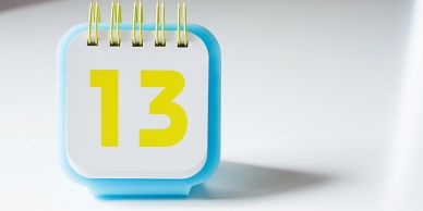A small desk calendar showing the number 13 in yellow.