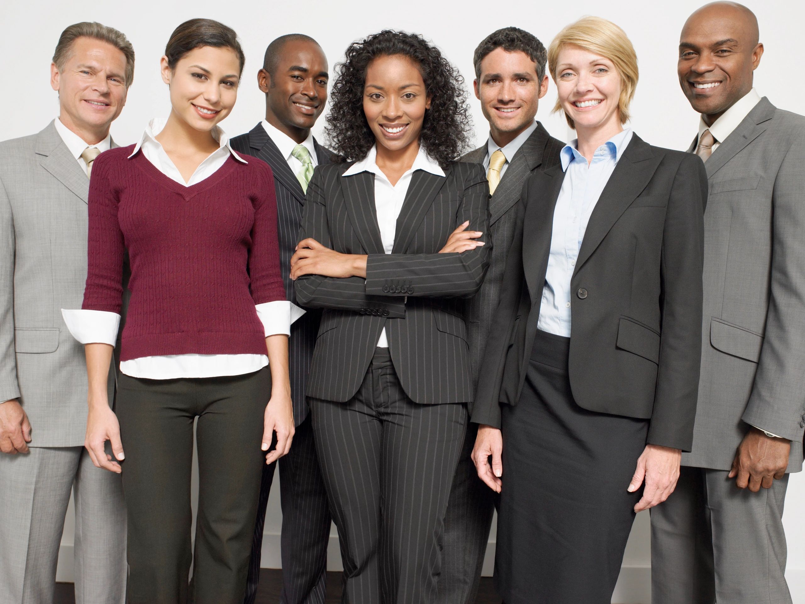 A diverse group of six professionals smiling and standing confidently together.