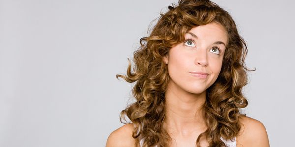 A scenic view of a mountain range under a clear blue sky with a few clouds.