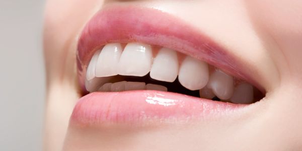 Close-up of a smiling mouth showing healthy white teeth.
