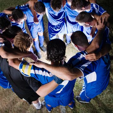 Soccer team huddling before a match.