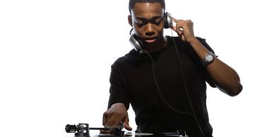 DJ playing music on turntables with headphones.