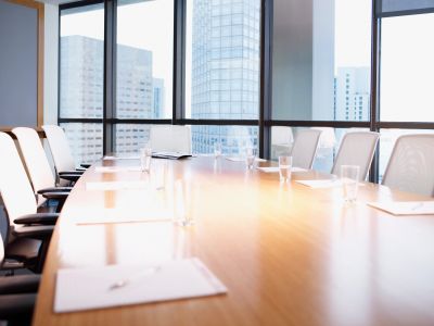 Empty boardroom with glass windows and city view.