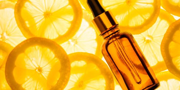 Amber dropper bottle with lemon slices background.