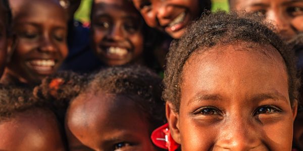 A group of joyful children smiling brightly at the camera.