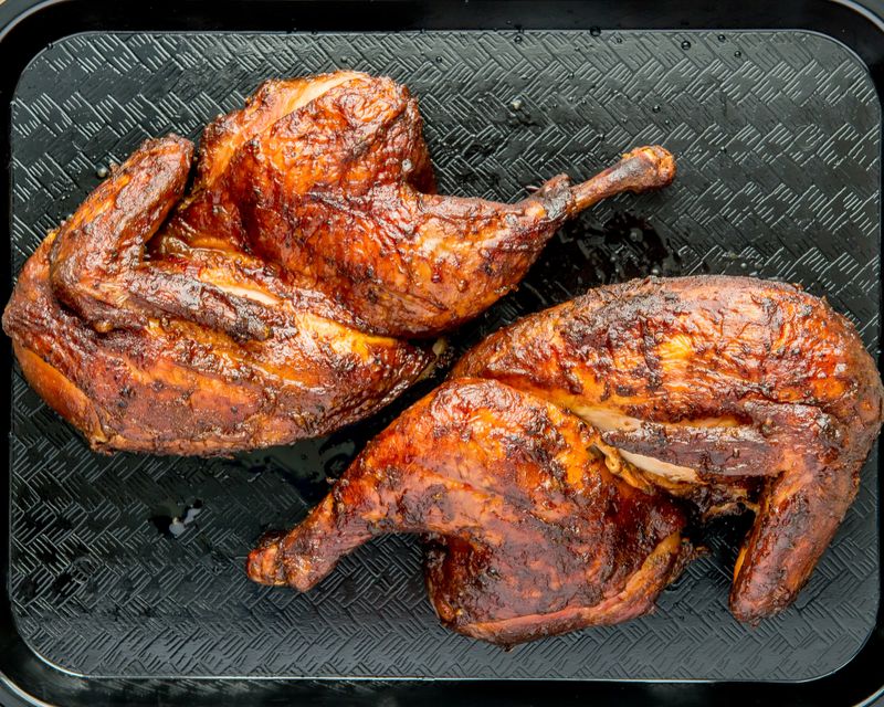 Smoked barbecue half chicken with South Carolina yellow barbecue sauce.
