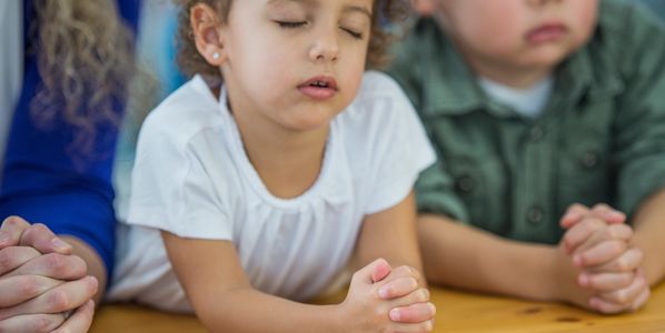 Kids sitting on the floor doing stretching exercises.